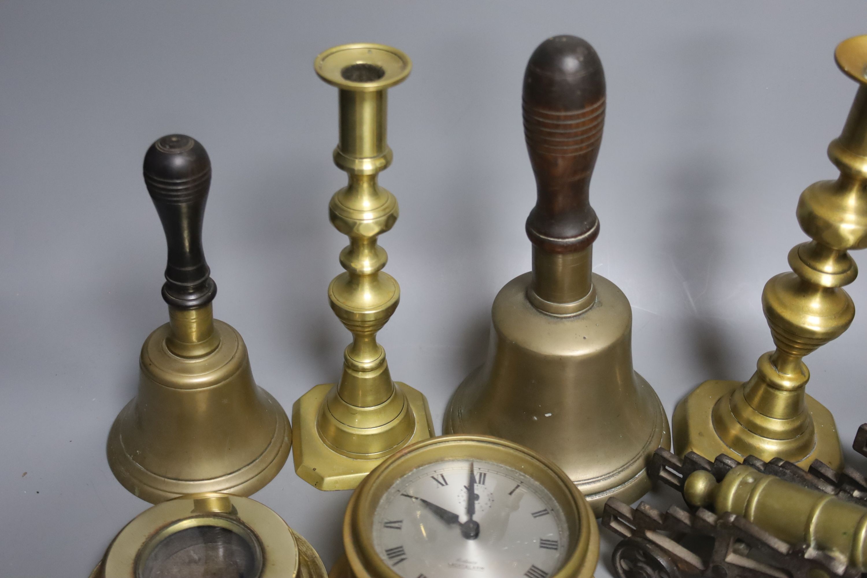 A quantity of brassware including bells, model cannons, candlesticks etc.
